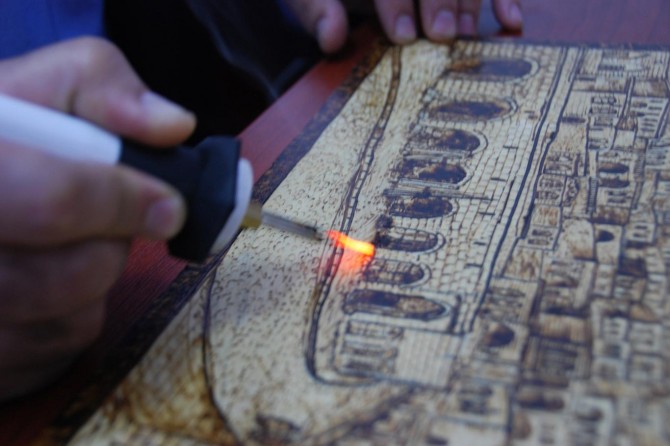 Ahşaba çizdiği resimlerle tarihi yansıtıyor