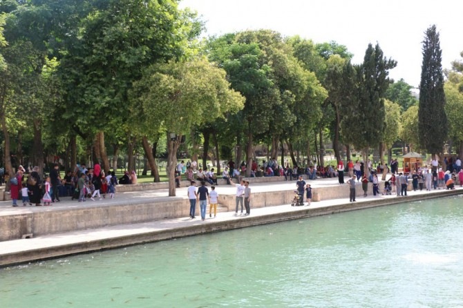 Sıcaklardan bunalan Şanlıurfalılar Balıklı Göl'de dinleniyor