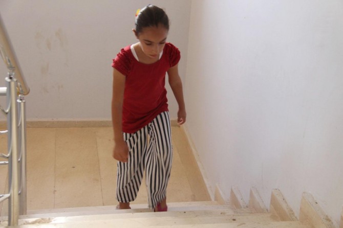 Ayakları çarpık olan küçük kız yardım bekliyor