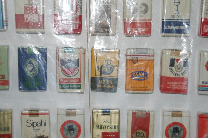 Bir zamanlar reklam için kullanılan sigara paketlerini sergiliyor
