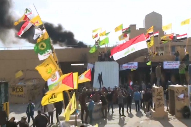 People continue their protest outside the US Embassy in Baghdad