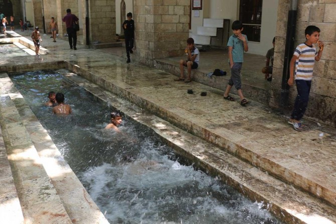 Şanlıurfalı çocuklar cami içerisinden geçen su kanalında serinledi