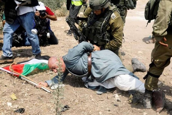 Zionist soldiers assault an old Palestinian farmer in occupied West Bank