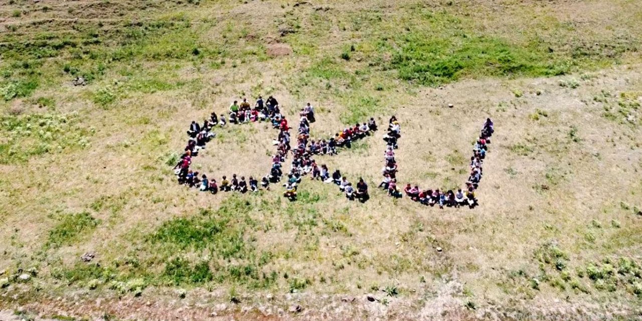 Çocuklar kırlarda kitap okuyup uçurtma uçurdu